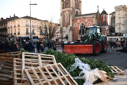 Los agricultores junto a un montón de escombros participan en una jornada nacional de acciones y bloqueos de carreteras convocada por varios sindicatos agrícolas para protestar contra los aumentos de los costos de producción y las regulaciones ambientales, en Agen, suroeste de Francia, el 25 de enero de 2024.