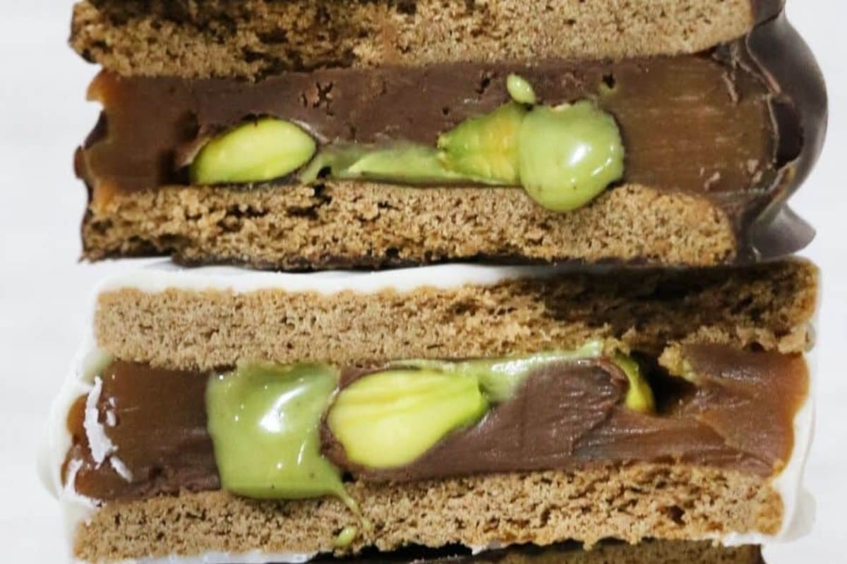 Los alfajores de Camboya de chocolate semiamargo relleno con Nutella, pistachos y dulce de leche; y de chocolate blanco relleno con Nutella, pistachos y dulce de leche