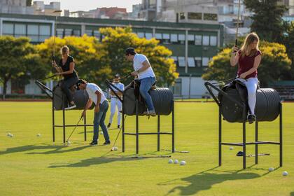 Los alumnos acostumbrándose al taco largo arriba de los caballos de "madera"