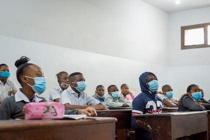 Los alumnos usan mascarillas en su salón de clases en la escuela Reverend Kim, en Kinshasa el 10 de agosto de 2020, tras la reanudación de las clases después del cierre por el coronavirus