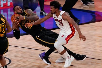 Los Angeles Lakers forward LeBron James pulls rebound away from Miami Heat forward Jimmy Butler during the second half in Game 5 of basketballs NBA Finals Friday, Oct. 9, 2020, in Lake Buena Vista, Fla