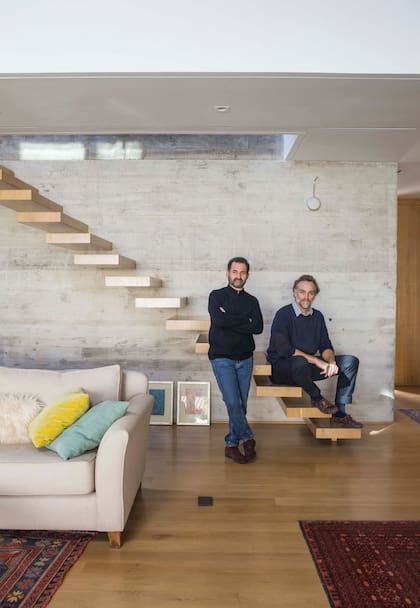 Los arquitectos Sebastián Krymkiewiez y Matías Clutterbuck, socios de SCK Arquitectos, en la segunda casa que diseñaron para la misma familia. La escalera tiene gran protagonismo, hecha en voladizo con estructuras metálicas empotradas y revestidas con el mismo roble americano del piso.