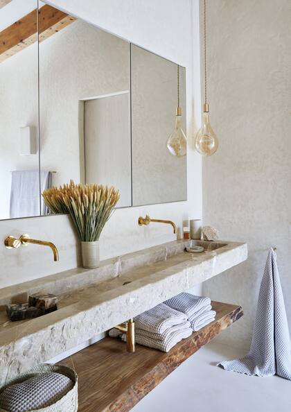 Los artesanos de More Decor tallaron la mesada de los baños en suite con terminación rústica siguiendo el estilo de la bacha de la cocina