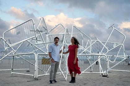 Los artistas cubano-americanos Rubén Millares y Antonia Wright posan con su escultura de luz titulada Patria y Vida durante la Semana de Arte de Miami, el 1 de diciembre de 2022 en Miami Beach, Florida. (AP Foto/Lynne Sladky)