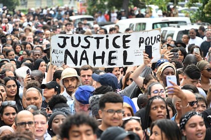 Los asistentes sostienen una pancarta que dice "Justicia para Nahel", durante una marcha de conmemoración de un conductor adolescente asesinado a tiros por un policía, en el área de Pablo Picasso del suburbio parisino de Nanterre, el 29 de junio de 2023