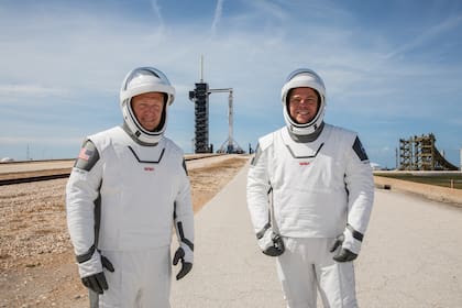 Los astronautas Douglas Hurley y Robert Behnken posan con sus trajes espaciales frente a la plataforma de lanzamiento del cohete Falcon 9, que los llevará a la Estación Espacial Internacional con la cápsula Crew Dragon en el primer vuelo comercial autorizado por la NASA
