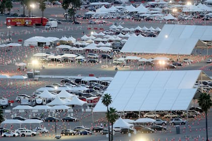 Los autos hacen fila en el sitio de vacunación masiva contra el coronavirus en el Dodger Stadium el 23 de febrero de 2021 en Los Ángeles, California
