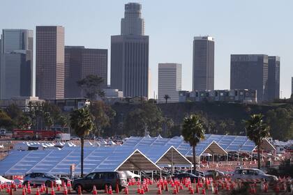 Los autos hacen fila en el sitio de vacunación masiva contra el coronavirus en el Dodger Stadium el 23 de febrero de 2021 en Los Ángeles, California