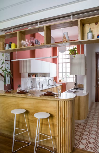 Los bajomesadas y alacenas se resolvieron de manera económica: con MDF pintado con látex blanco y fenólico de pino teñido en la tonalidad del roble. Banquetas (Cúmulo). Juego de vajilla sobre la isla (Colbo). Piso diseñado a medida por Terra Calcáreos. Paredes pintadas con Acrilplast ‘0058’ (Sinteplast).