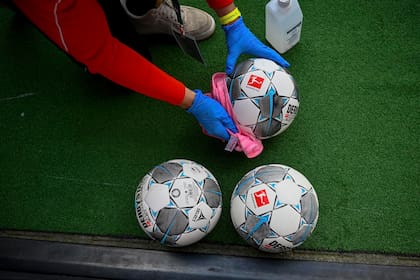 Los balones de fútbol se desinfectan durante el partido de fútbol de la Bundesliga entre Düsseldorf y Paderborn en el Merkur Spiel-Arena, Düsseldorf, Alemania, el sábado 16 de mayo de 2020. La Bundesliga alemana se convierte en la primera gran liga de fútbol del mundo en reanudarse después de una su