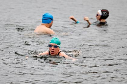 Los bañistas nadan en el Serpentine Lido en Hyde Park, Londres, mientras se alivian las restricciones de bloqueo del tercer Covid-19 de Inglaterra, lo que permite la apertura de instalaciones deportivas al aire libre el 29 de marzo de 2021