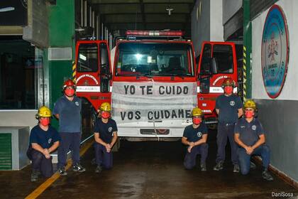 Los bomberos acuartelados, junto a la autobomba decorada con el tapabocas