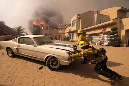 Los bomberos intentaban salvar un auto en una casa en llamas en Malibú