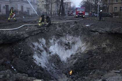 Los bomberos trabajan cerca de un cráter ocasionado por un ataque ruso en Kiev, Ucrania, el jueves 21 de marzo de 2024
