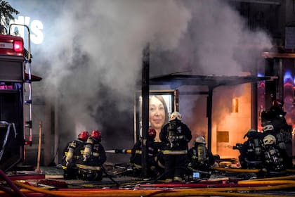 Los bomberos trabajan en el incendio de la perfumería