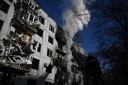 Los bomberos trabajan para combatir un incendio en un edificio, después de los bombardeos en la ciudad de Chuguiv