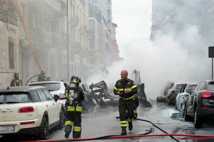 Los bomberos trabajan para extinguir un incendio en un edificio tras la explosión de una furgoneta en el centro de Milán, en el norte de Italia, el jueves 11 de mayo de 2023.