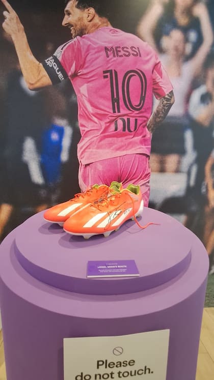 Los botines de Lionel Messi, exhibidos junto a imágenes del capitán argentino en el estadio de Inter Miami.