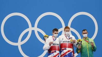 Los británicos Tom Dean y Duncan Scott con el brasileño Fernando Scheffer recibiendo sus respectivas medallas