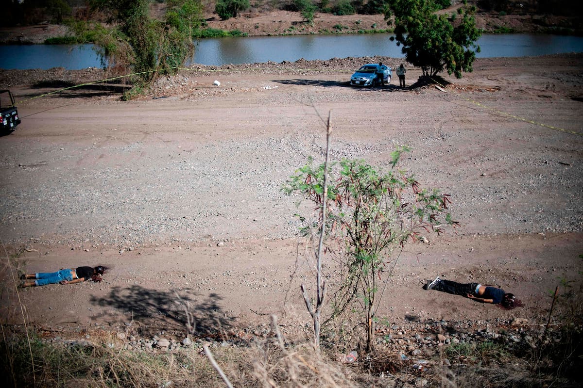Los cadáveres de dos hombres asesinados en una disputa entre carteles yacen en un paraje de Sinaloa