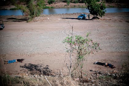 Los cadáveres de dos hombres asesinados en una disputa entre carteles yacen en un paraje de Sinaloa