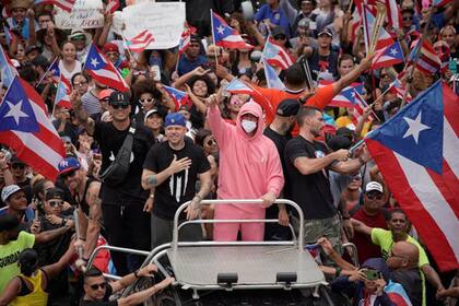 Los cantantes Residente (izquierda) y Bad Bunny (centro) encabezaron, ayer, una marcha en San Juan de Puerto Rico
