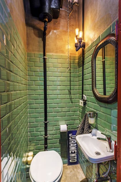 Los cerámicos verde Tiffany (Deco Arribeños) se acompañan con cemento alisadoen paredes y piso. En contraste, bacha blanca (Roca) con grifería (FV).