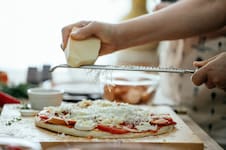 No todos sirven ni van en cualquier pizza: el queso exacto que usan las pizzerías para al molde, a la piedra y napolitana