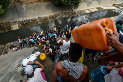 Los ciudadanos más necesitados de Caracas utilizan el contaminado río Guaire para abastecerse