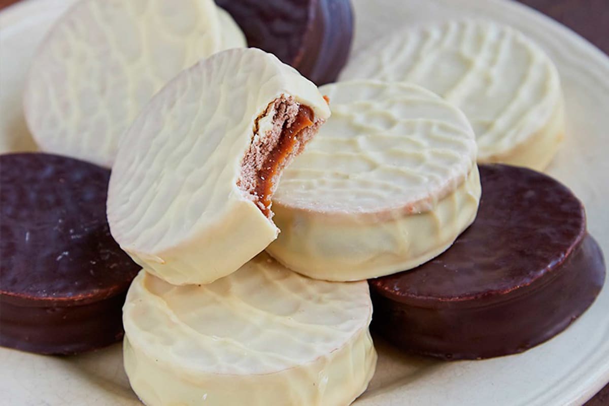 Los clásicos alfajores rellenos de dulce de leche bañados en chocolate y bañados de chocolate blanco.