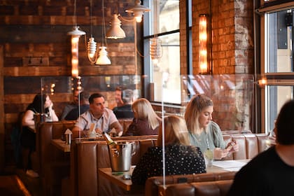 Los clientes se sientan en cabinas separadas por pantallas de perspex en un bar, Alberts Schloss, en Manchester, noroeste de Inglaterra, el 4 de julio de 2020