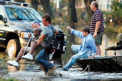 Los colaboradores Matt Taibbi, Sean Penn y Douglas ayudan a un anciano a encontrar un lugar seguro en Nueva Orleans, en 2005
