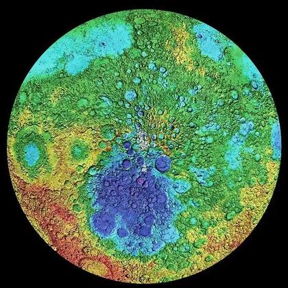 Los colores muestran altitudes en el Polo Sur de la Luna, desde púrpura (profundidad de más de 9.000 mt), al verde (cero altitud), amarillo (2.000 mt sobre el nivel de la superficie), naranja (4.000 mt de altura) y rojo (8.200). La cuenca Aitken, un cráter de unos 2.500 km de diámetro y 12 km de profundidad, es la gran mancha púrpura y azul oscura