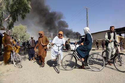 Los combates entre talibanes y fuerzas de seguridad afganas provocan una columna de humo en Kandahar, al suroeste de Kabul, Afganistán, el 12 de agosto de 2021. (AP Foto/Sidiqullah Khan)