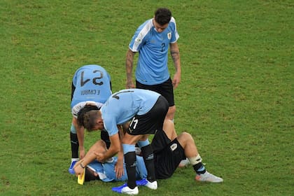 Los compañeros de la selección de Uruguay le dan un consuelo a Suárez (en el suelo), el único en fallar en los penales
