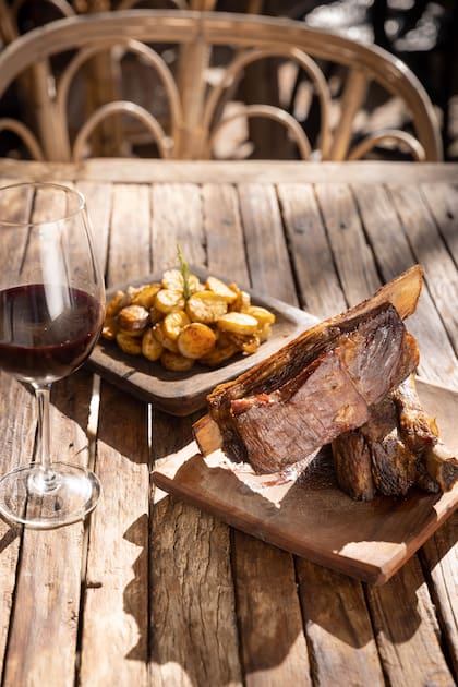 Los cortes de carne premium como vacío, picaña y ojo de bife con hueso llegan en su punto justo en tablas de madera.