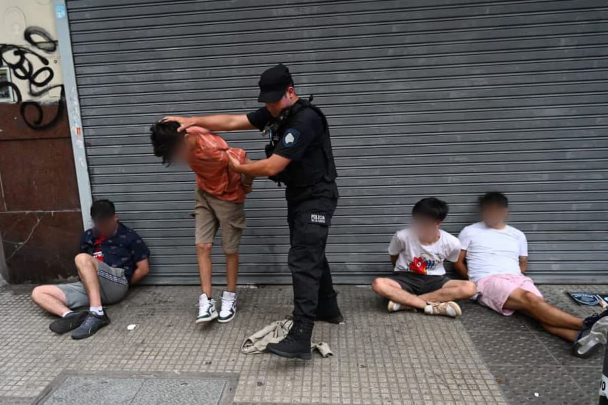 Los cuatro detenidos, esposados en la esquina de Sarmiento y Uruguay