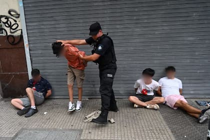 Los cuatro detenidos, esposados en la esquina de Sarmiento y Uruguay