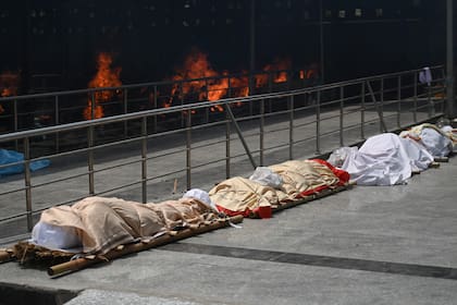 Los cuerpos de las víctimas del coronavirus se alinearon antes de la cremación en un campo de cremación en Nueva Delhi