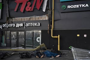 Los cuerpos de los militares ucranianos están cubiertos con mantas y bolsas de plástico fuera del centro comercial Retroville luego de un ataque con misiles rusos en Kiev el 21 de marzo de 2022