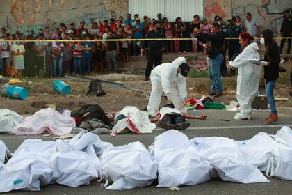 Los cuerpos en bolsas para cadáveres se colocan a un costado de la carretera después de un accidente en Tuxtla Gutiérrez, estado de Chiapas, México, el 9 de diciembre de 2021. (AP Foto )