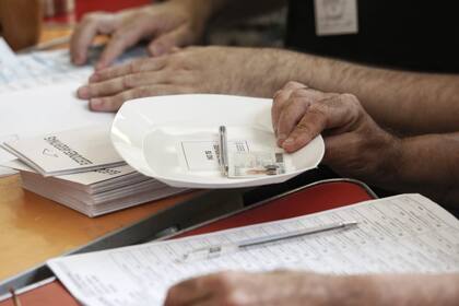 Los electores deben presentar su documento a la mes de votación