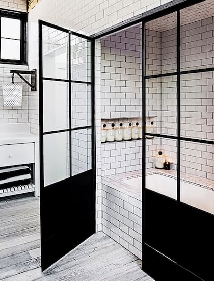 Los elementos negros del baño contrastan con los muebles lacados en blanco