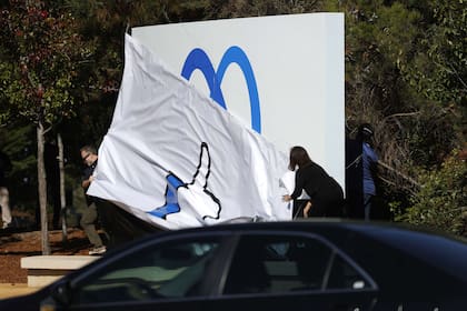 Los empleados de Facebook presentan un nuevo logotipo y el nombre 'Meta' en el letrero frente a la sede de Facebook el 28 de octubre de 2021 en Menlo Park
