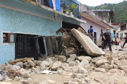 Los enseres de una vivienda, en una calle tras las inundaciones y deslaves provocados por las lluvias torrenciales en Tovar, en el estado de Mérida, en Venezuela, el 26 de agosto de 2021. (AP Foto/Luis Bustos)