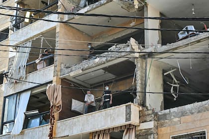 Los equipos de primera intervención inspeccionan los daños en el lugar de un ataque aéreo israelí contra apartamentos en un edificio residencial en los suburbios del sur de Beirut