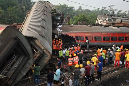 Los equipos de rescate se reúnen alrededor de los vagones dañados en el lugar del accidente de una colisión de tres trenes cerca de Balasore, a unos 200 km de la capital del estado, Bhubaneswar, en el estado oriental de Odisha, el 3 de junio de 2023