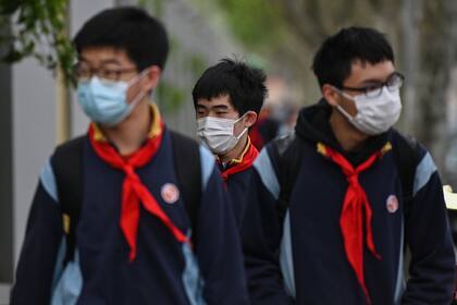 Los estudiantes que usan mascarillas para protegerse del coronavirus llegan a la Escuela Intermedia Huayu en Shanghai el 27 de abril de 2020