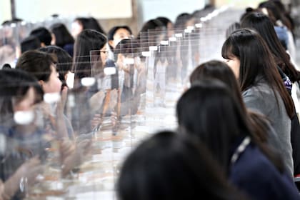 Los estudiantes secundarios de la escuela de Daejeon almuerzan separados por barreras de plástico