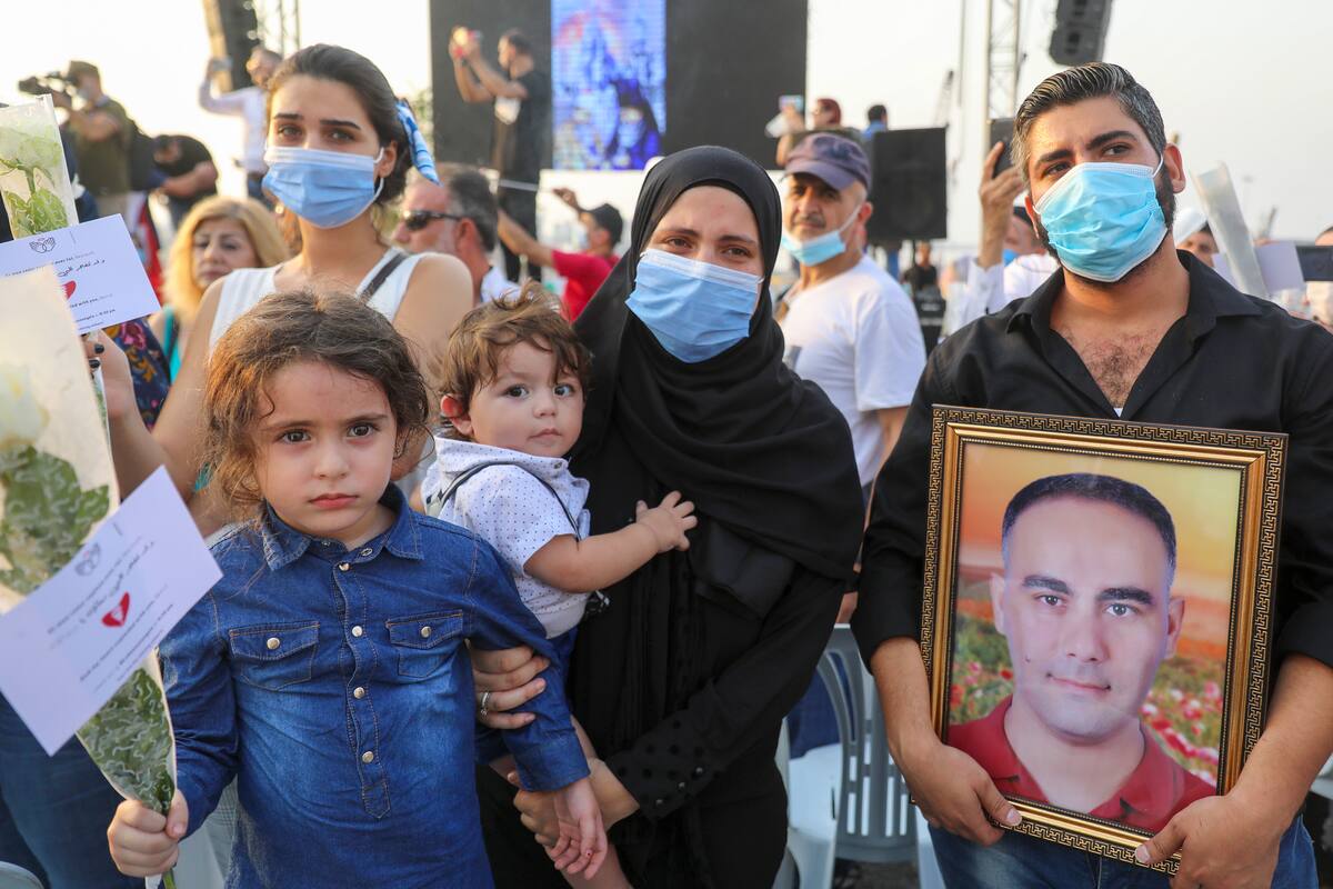Los familiares de una de las víctimas sirias de la explosión de Beirut llevan su retrato durante una manifestación para conmemorar un mes desde la catastrófica explosión del 4 de agosto, en la capital libanesa, Beirut, el 4 de septiembre de 2020